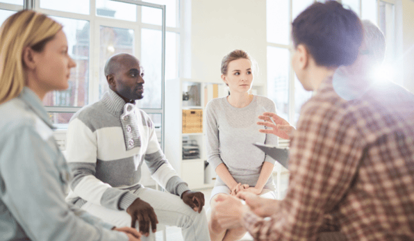 group of men and women sitting in circle